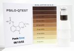 A Penis Envy evaluation scale is displayed next to a vial of brown liquid. The scale ranges from "0 mg (0%)" to "24 mg (2.4%)". A booklet is open beside the scale, showing a chemical structure and text that reads "PSILO-QTEST" and "Penis Envy 08/13/22".